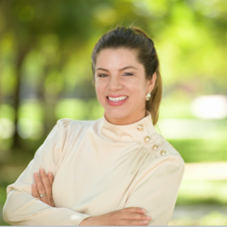 Alexandra Rollins, Director of Employee and Organizational Development Programs at UC Riverside, wearning a beige blouse with gold buttons on the left side that match her earing, smiling for headshot