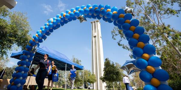 UCR Bell Tower behind a blue and gold balloon arch