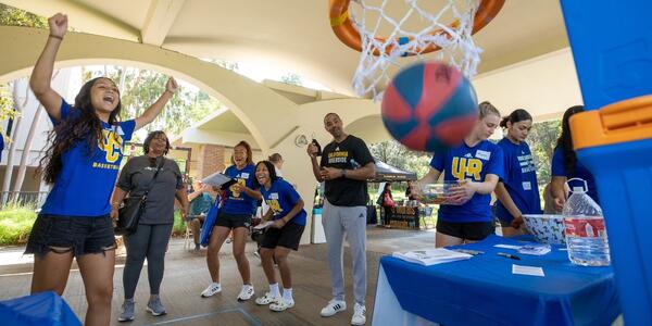 UCR Women's Basketball cheering as a Community Partner Fair attendee made their shot into the hoop