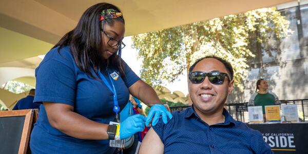 A UCR employee receiving a free flu shot from UCR Health at the 2022 Community Partner Fair