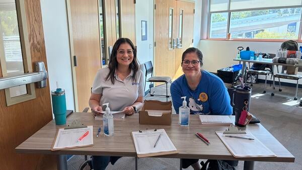 Two staff volunteers at the event sign-in station.