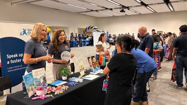 Community Partner Fair vendor chatting with event attendees.