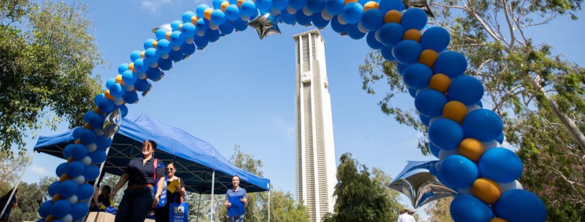 UCR Bell Tower behind a blue and gold balloon arch