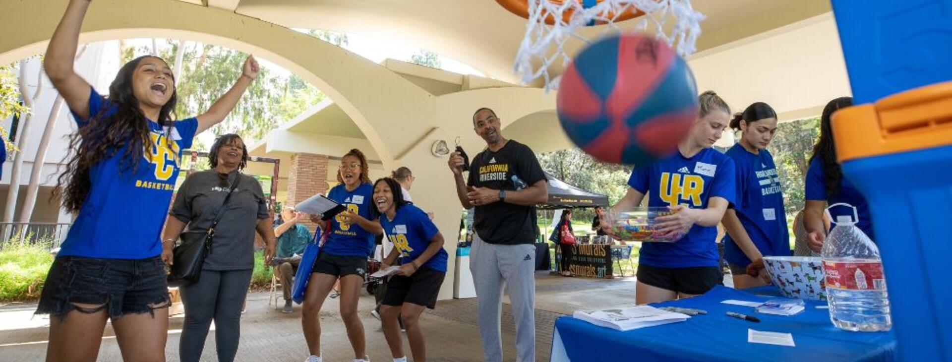 UCR Women's Basketball cheering as a Community Partner Fair attendee made their shot into the hoop