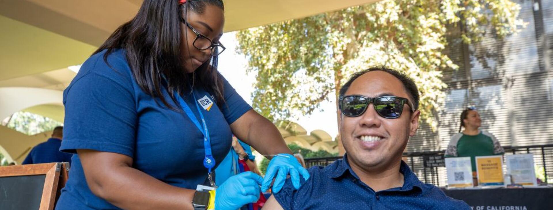A UCR employee receiving a free flu shot from UCR Health at the 2022 Community Partner Fair