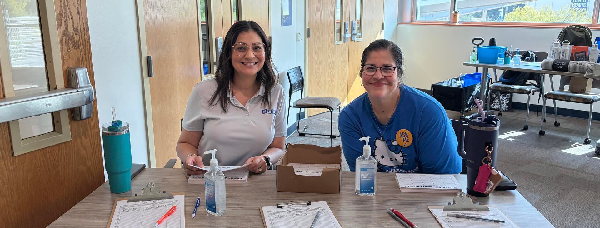 Two staff volunteers at the event sign-in station.